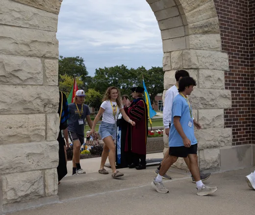 students walking through arch